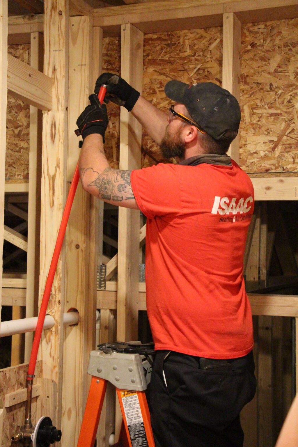 An employee installing some plumbing valves in the unfinished house.