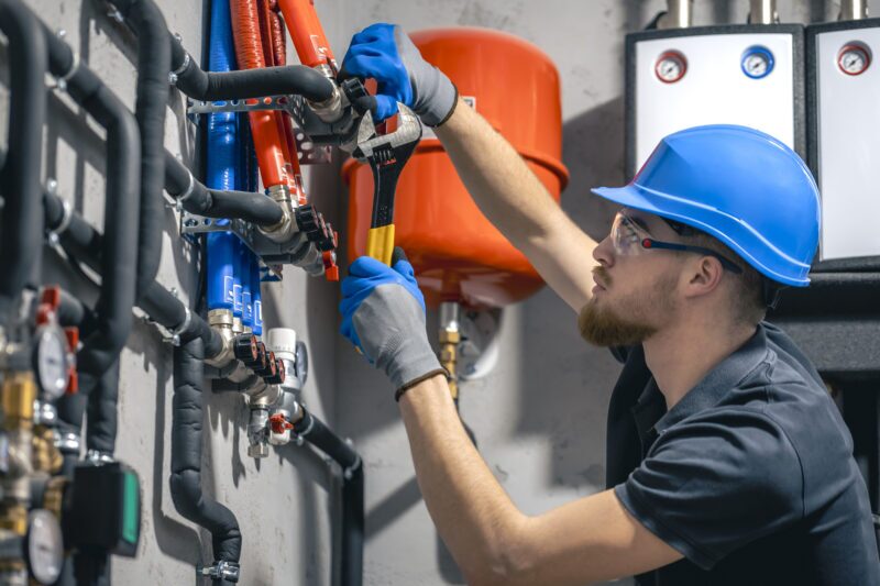 A man installs a heating system in a residential building