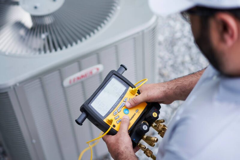 An employee using a test instrument to ensure that the outside heater is working